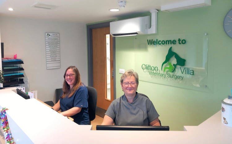 Two smiling women sat at the Clifton Villa Vet front desk